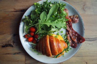 yumurta ve pastırma tahta arka plan ile kruvasan