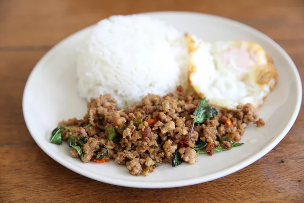 Revuelve el cerdo frito y la albahaca servidos con arroz y huevo frito — Foto de Stock