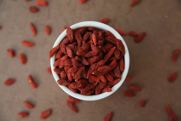 Trockene rote Goji-Beeren auf Holz-Hintergrund — Stockfoto