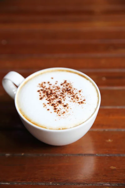 Cappuccino kahve kahve dükkanında ahşap arka plan üzerinde — Stok fotoğraf