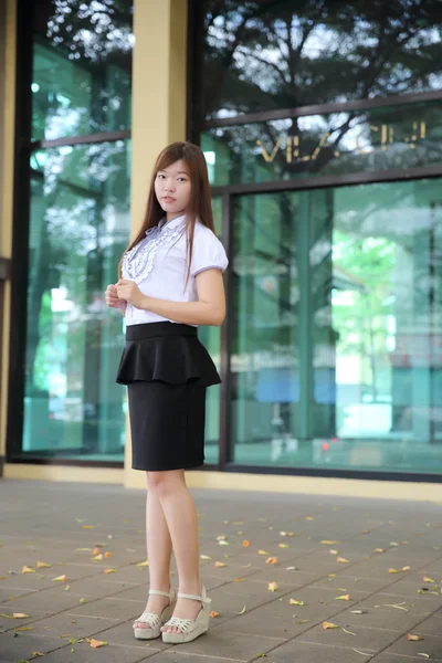 Молодая азиатская деловая женщина, стоящая на фоне офиса — стоковое фото