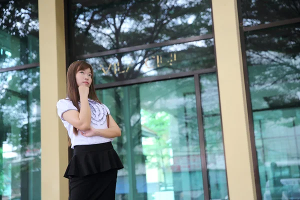オフィスの背景の上に立っている若いアジア ビジネス女性 — ストック写真