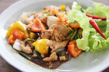 Ahşap arka plan üzerinde Fry tavuk karabiber ile karıştırın