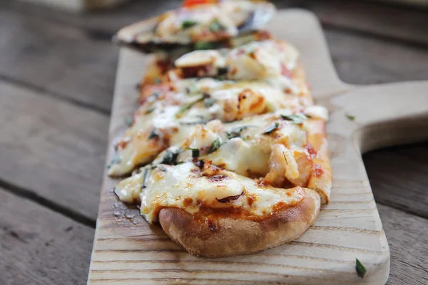 Пицца с морепродуктами на фоне дерева итальянская еда — стоковое фото