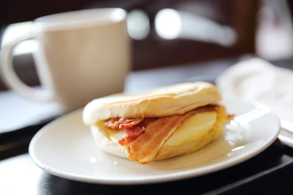 Bacon en gebakken ei broodje met koffie — Stockfoto