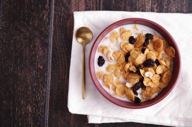 Mısır yulaflı mısır gevreği ve ahşap arka planda izole edilmiş kuru meyveler.
