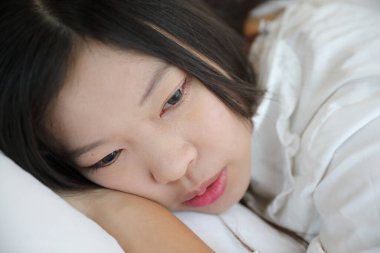 Kız beyaz yatak odasında yastıkla uyuyor.