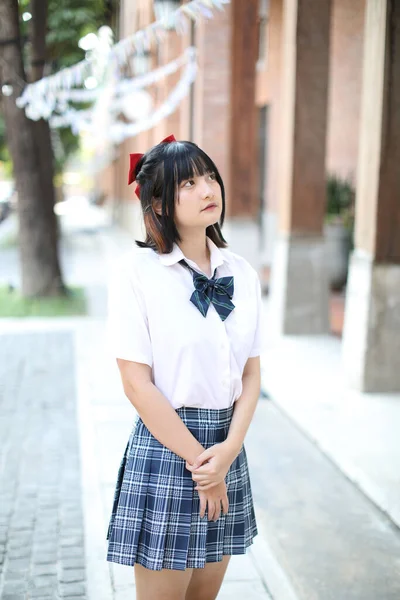 アジア系の女子高生が街を歩き回り — ストック写真