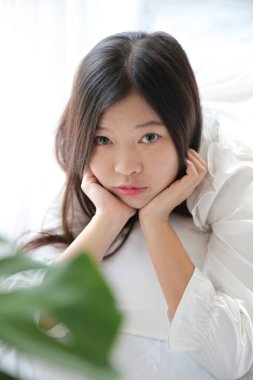 Kız beyaz yatak odasında yastıkla uyuyor.