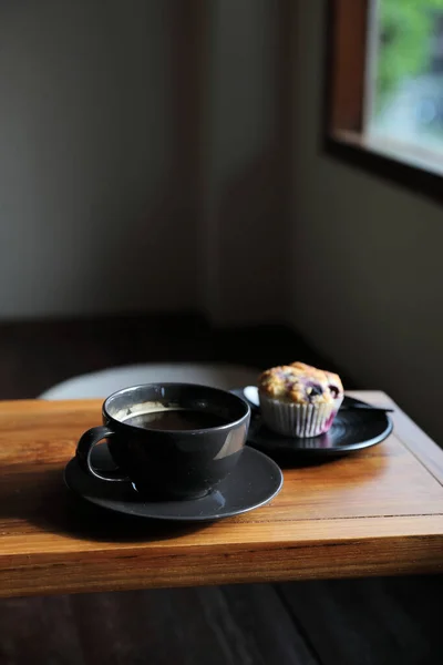 当地咖啡店木桌上有松饼的咖啡杯 — 图库照片