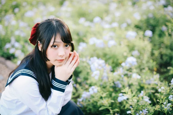 Asiatico Scuola Ragazza Seduta Con Fiore Giardino Sfondo — Foto Stock