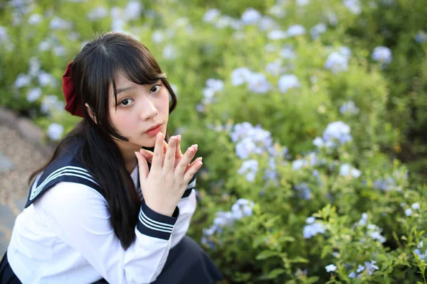 Asiatico Scuola Ragazza Seduta Con Fiore Giardino Sfondo — Foto Stock