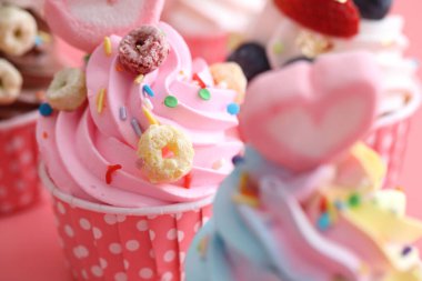 Pembe arkaplanda izole edilmiş renkli kekler