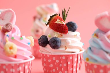 Pembe arkaplanda izole edilmiş renkli kekler