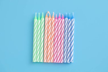 Mavi arkaplanda izole edilmiş renkli mumlar