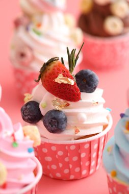 Pembe arkaplanda izole edilmiş renkli kekler