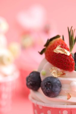 Pembe arkaplanda izole edilmiş renkli kekler