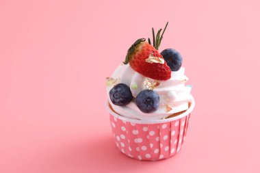 Meyveli kek pembe arka planda izole edilmiş.