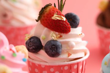 Pembe arkaplanda izole edilmiş renkli kekler