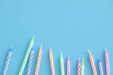 Mavi arkaplanda izole edilmiş renkli mumlar