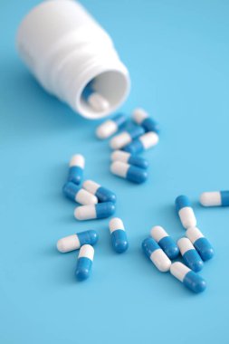 Mavi arka planda izole edilmiş şişe kapsülleri