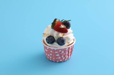 Meyveli kek mavi arkaplanda izole edilmiş.