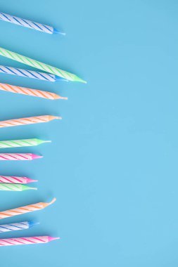 Mavi arkaplanda izole edilmiş renkli mumlar