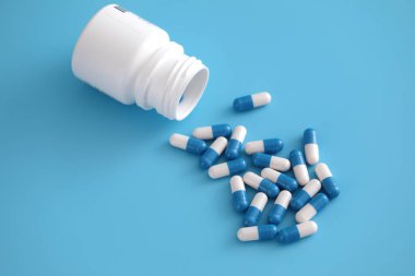 Mavi arka planda izole edilmiş şişe kapsülleri