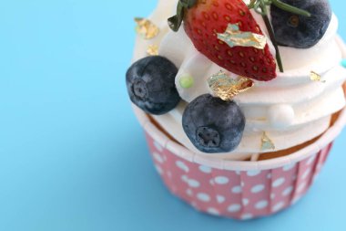 Meyveli kek mavi arkaplanda izole edilmiş.