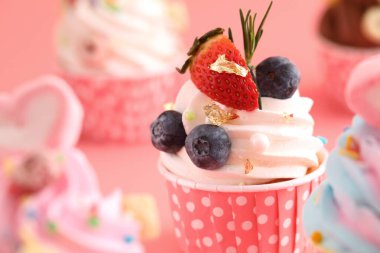 Pembe arkaplanda izole edilmiş renkli kekler