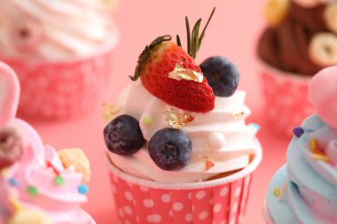 Pembe arkaplanda izole edilmiş renkli kekler