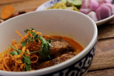 Kuzey Tayland yemekleri, ahşap arka planda domuz pirzolası ve körili erişte.