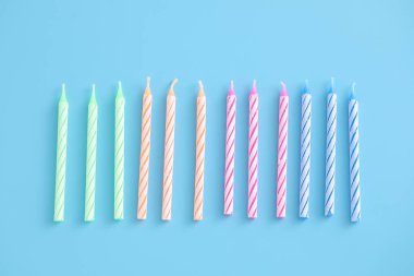 Mavi arkaplanda izole edilmiş renkli mumlar