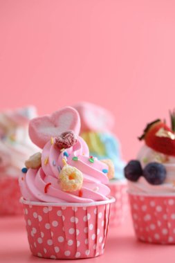 Pembe arkaplanda izole edilmiş renkli kekler