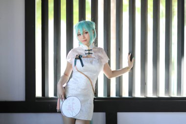 Japon anime kostüm portresi. Çin bahçesinde Çin elbisesi kostümü giymiş bir kız.