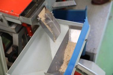 Fabrika makinesi pirinç öğütüyor.