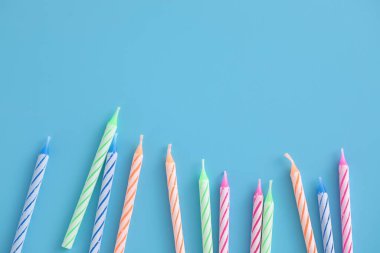 Mavi arkaplanda izole edilmiş renkli mumlar