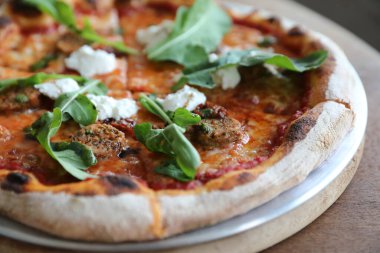 İtalyan sosisi ve roket salatalı pizza.