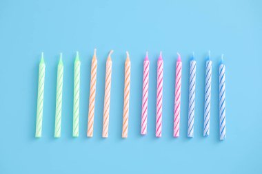 Mavi arkaplanda izole edilmiş renkli mumlar