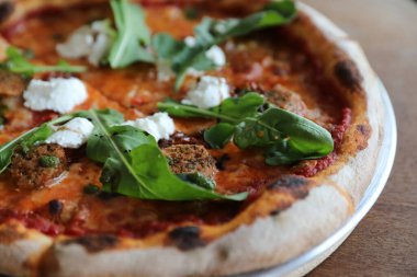 İtalyan sosisi ve roket salatalı pizza.