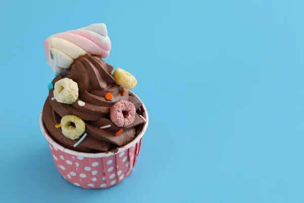 青い背景に隔離されたチョコレートカップケーキ — ストック写真