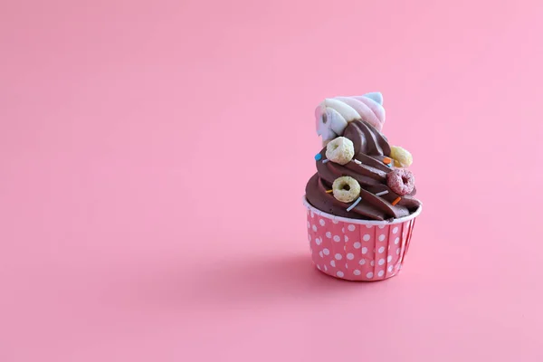 ピンクの背景に隔離されたチョコレートカップケーキ — ストック写真
