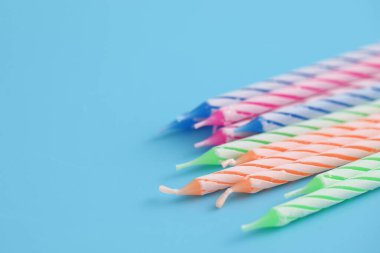 Mavi arkaplanda izole edilmiş renkli mumlar