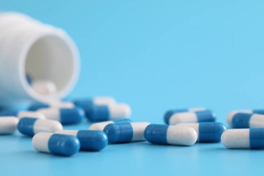 Mavi arka planda izole edilmiş şişe kapsülleri