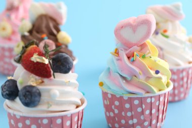 Mavi arkaplanda izole edilmiş renkli kekler