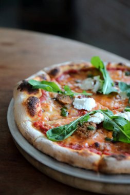 İtalyan sosisi ve roket salatalı pizza.