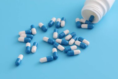 Mavi arka planda izole edilmiş şişe kapsülleri
