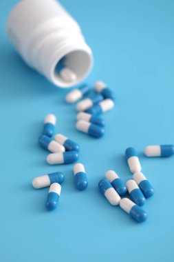 Mavi arka planda izole edilmiş şişe kapsülleri