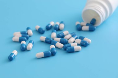 Mavi arka planda izole edilmiş şişe kapsülleri