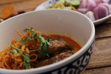 Kuzey Tayland yemekleri, ahşap arka planda domuz pirzolası ve körili erişte.